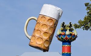 Ein riesiger Bierkrug steht am Eingang auf dem Festgelände Cannstatter Wasen, im Hintergrund steht die Fruchtsäule., © Bernd Weißbrod/dpa