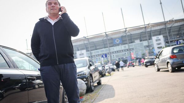 Thomas Wüstefeld, Noch-Vorstand des Hamburger SV, telefoniert vor einem Spiel auf dem Parkplatz vor dem Stadion., © Christian Charisius/dpa