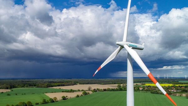 Eine Windenergieanlage des Herstellers Siemens steht auf einem Feld., © Patrick Pleul/dpa-Zentralbild/dpa/Archiv