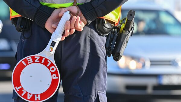Ein Polizeibeamter hält eine Winkerkelle in den Händen., © Patrick Pleul/dpa-Zentralbild/ZB/Symbolbild