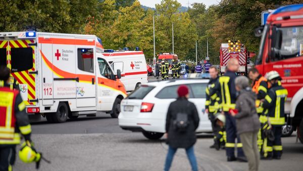 Einsatzkräfte der Feuerwehr und des Roten Kreuzes stehen nach einem Gasaustritt vor der Schule in Idstein, © Sebastian Gollnow/dpa
