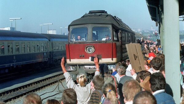 Von jubelnden Menschenmassen werden im Jahr 1989 Menschen aus der DDR am auf dem Bahnhof im bayerischen Hof empfangen, © Wolfgang Eilmes/dpa/Archivbild