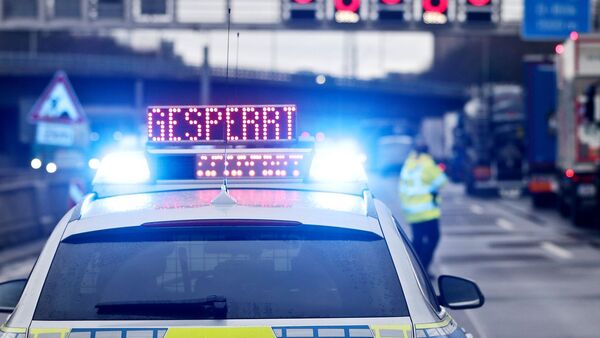 Auf einem Polizeifahrzeug leuchtet die Aufschrift «Gesperrt»., © David Young/dpa/Symbolbild