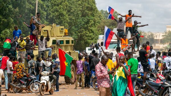 Anhänger von Hauptmann Traore jubeln mit russischen Fahnen in den Straßen von Burkina Fasos Hauptstadt Ouagadoudou., © Kilayé Bationo/AP/dpa
