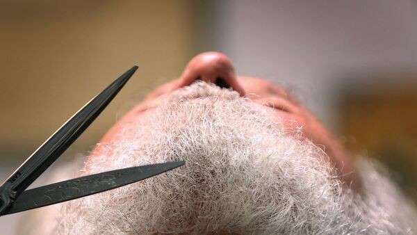 Einem Mitwirkenden der Passionsspiele wird in einem Friseur-Salon der Bart gestutzt., © Karl-Josef Hildenbrand/dpa