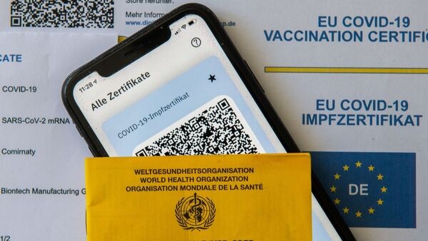 Ein Impfpass und ein Smartphone mit der CovPass-App., © Stefan Puchner/dpa/Symbolbild