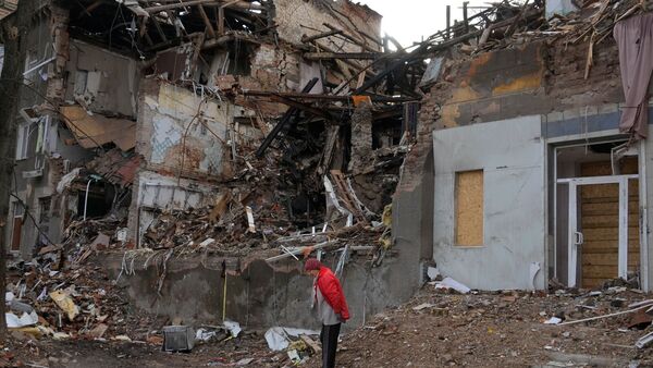 Eine Frau steht in der Nähe ihres Hauses, das durch Beschuss vor einem Monat zerstört wurde., © Efrem Lukatsky/AP/dpa
