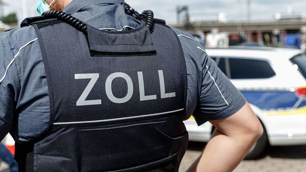 Ein Beamter trägt während seines Dienstes eine Schutzweste mit der Rückenaufschrift "Zoll"., © Markus Scholz/dpa/Symbolbild