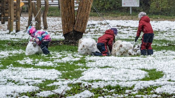 Kinder in Straubing versuchen, einen Schneemann zu bauen., © Armin Weigel/dpa
