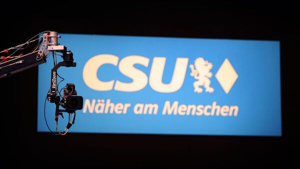 Eine Kamera hängt vor einem CSU-Logo., © Karl-Josef Hildenbrand/dpa/Archivbild