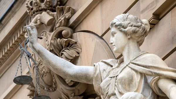 Vor dem Gebäude eines Amt- und Landgerichts hält eine Statue der Göttin Justitia eine Waagschale., © Stefan Puchner/dpa/Archivbild